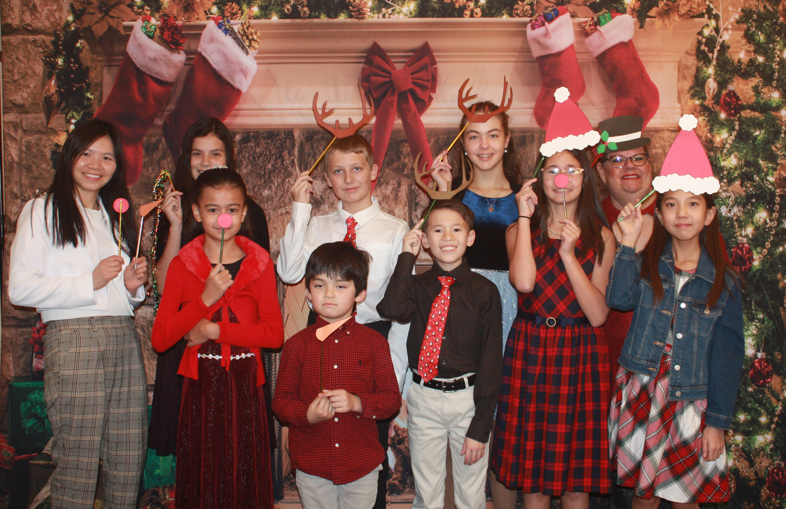 Students posing after a Christmas recital with Christmas decor.