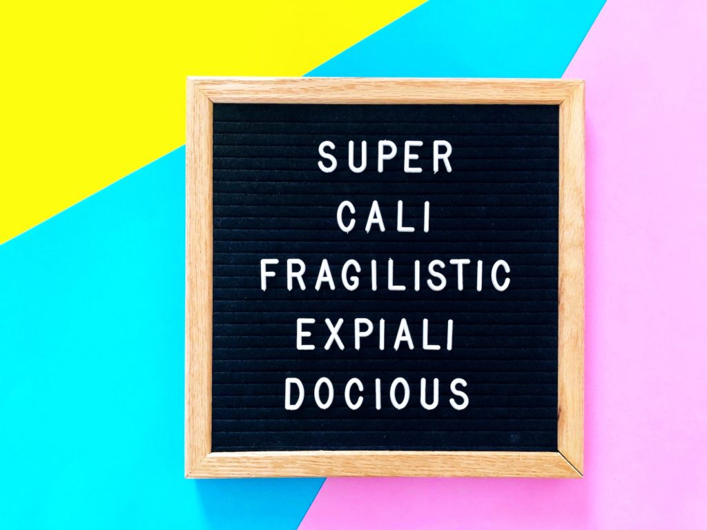 Supercalifragilisticexpialidocious lyrics in a picture frame in front of color blocks.