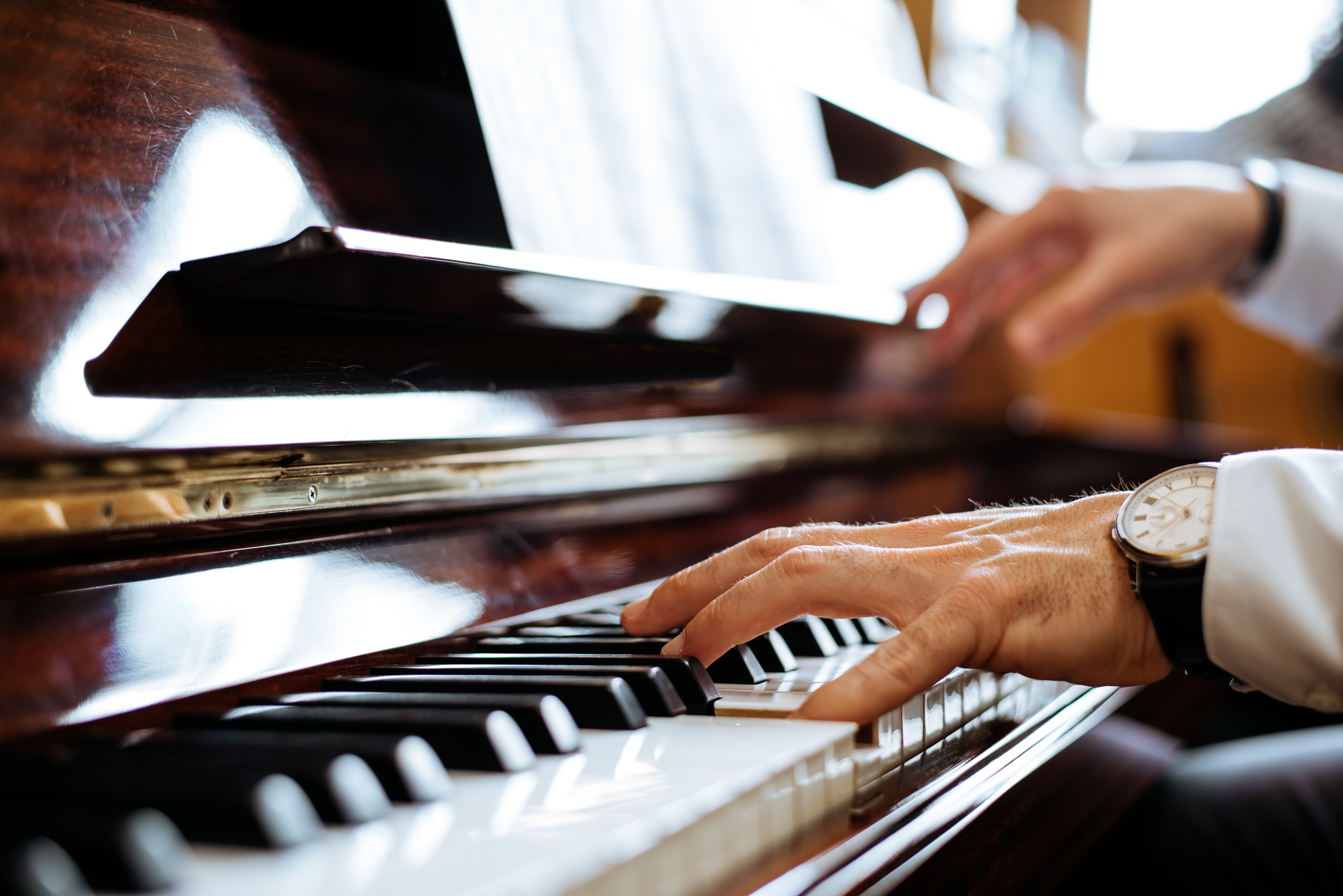 An adult who may be susceptible to perfectionism is playing the piano.