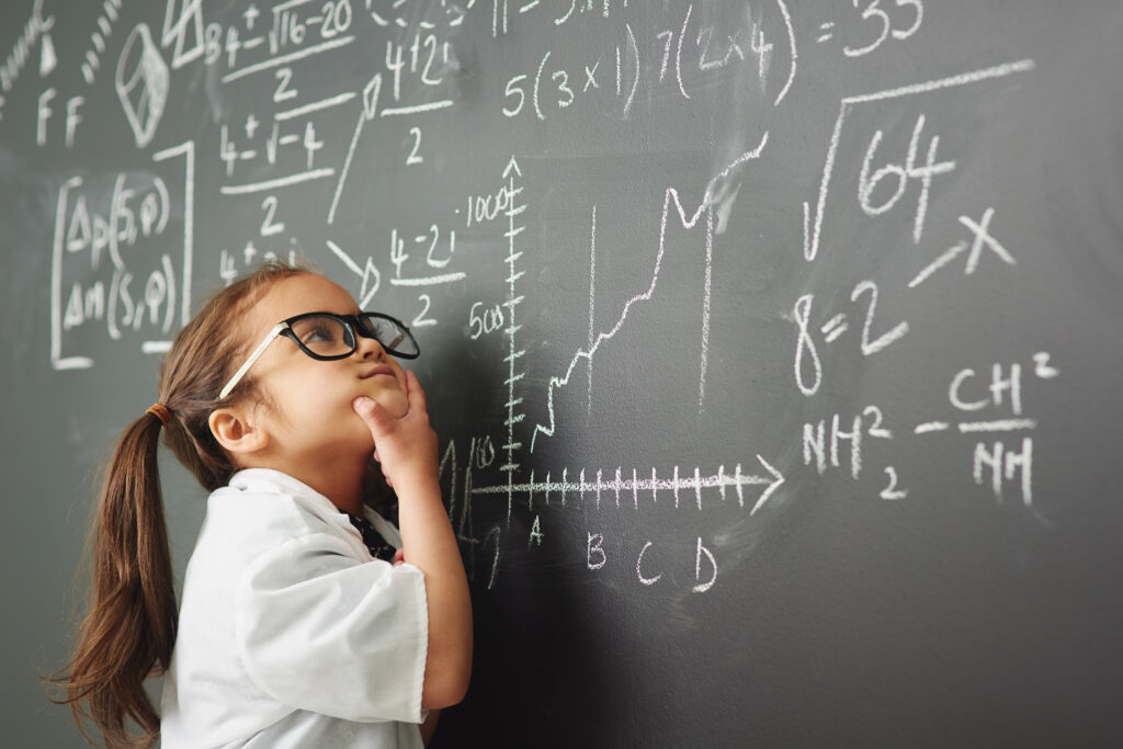 A young girl, who is considered gifted, and may be susceptible to perfectionism, studies a chalkboard