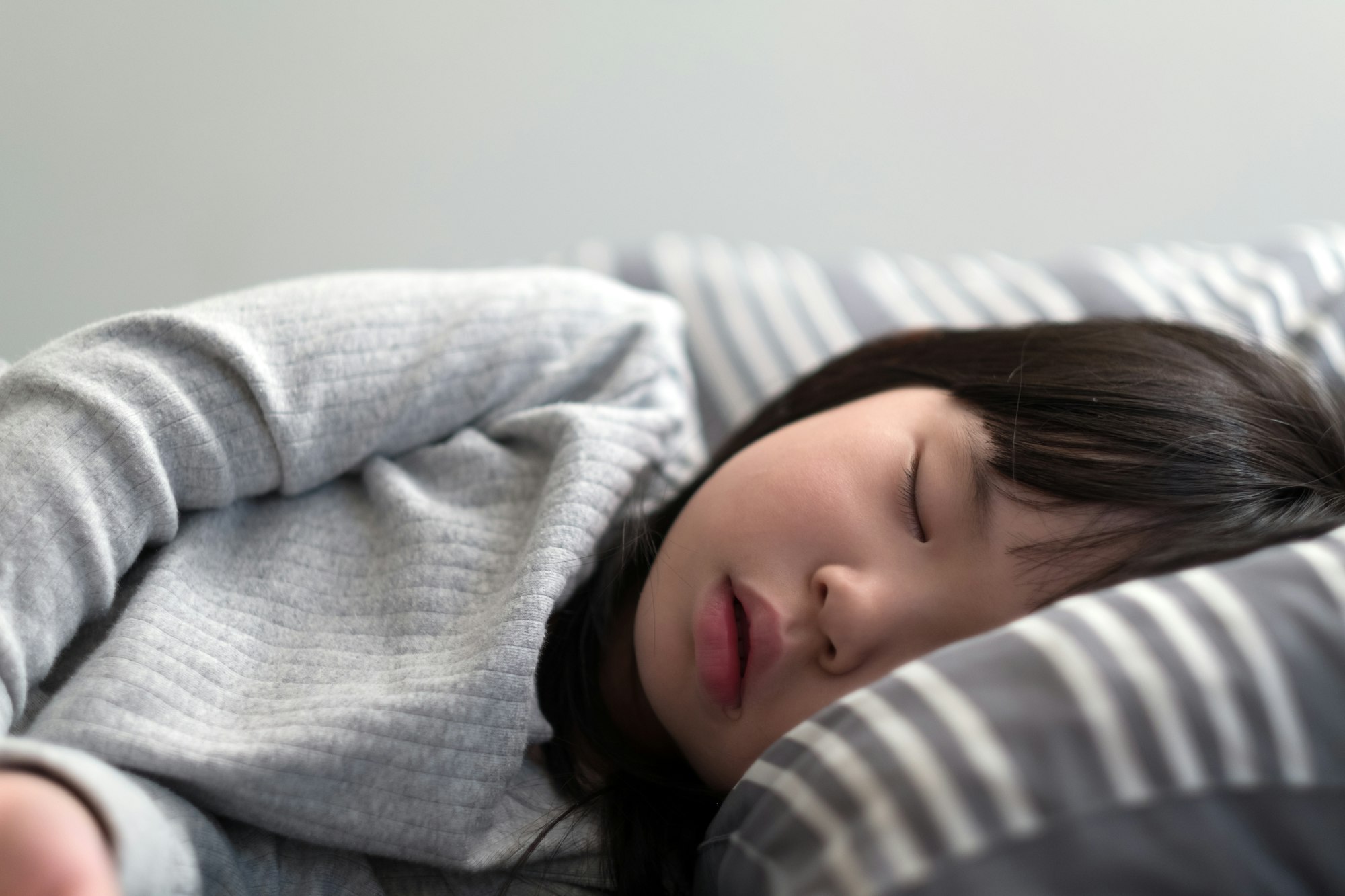 Child girl sleeping on bed. Proper sleep habits are part of a pre-memorization technique. 