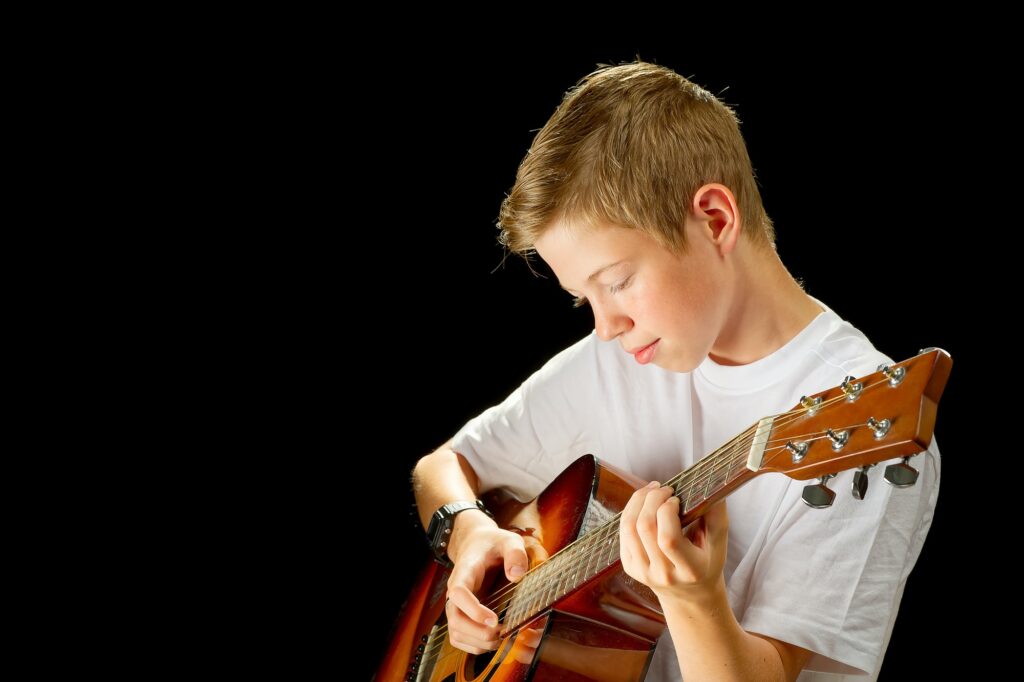 A young boy excited to play guitar for contest