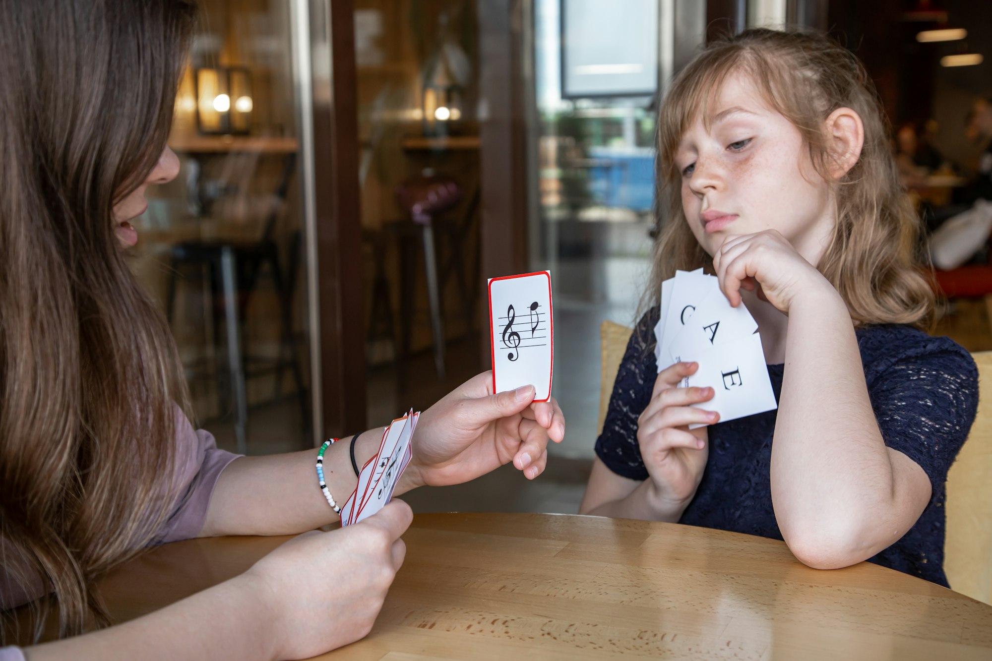 A mom and daughter using music note flashcards to visualize when memorizing.