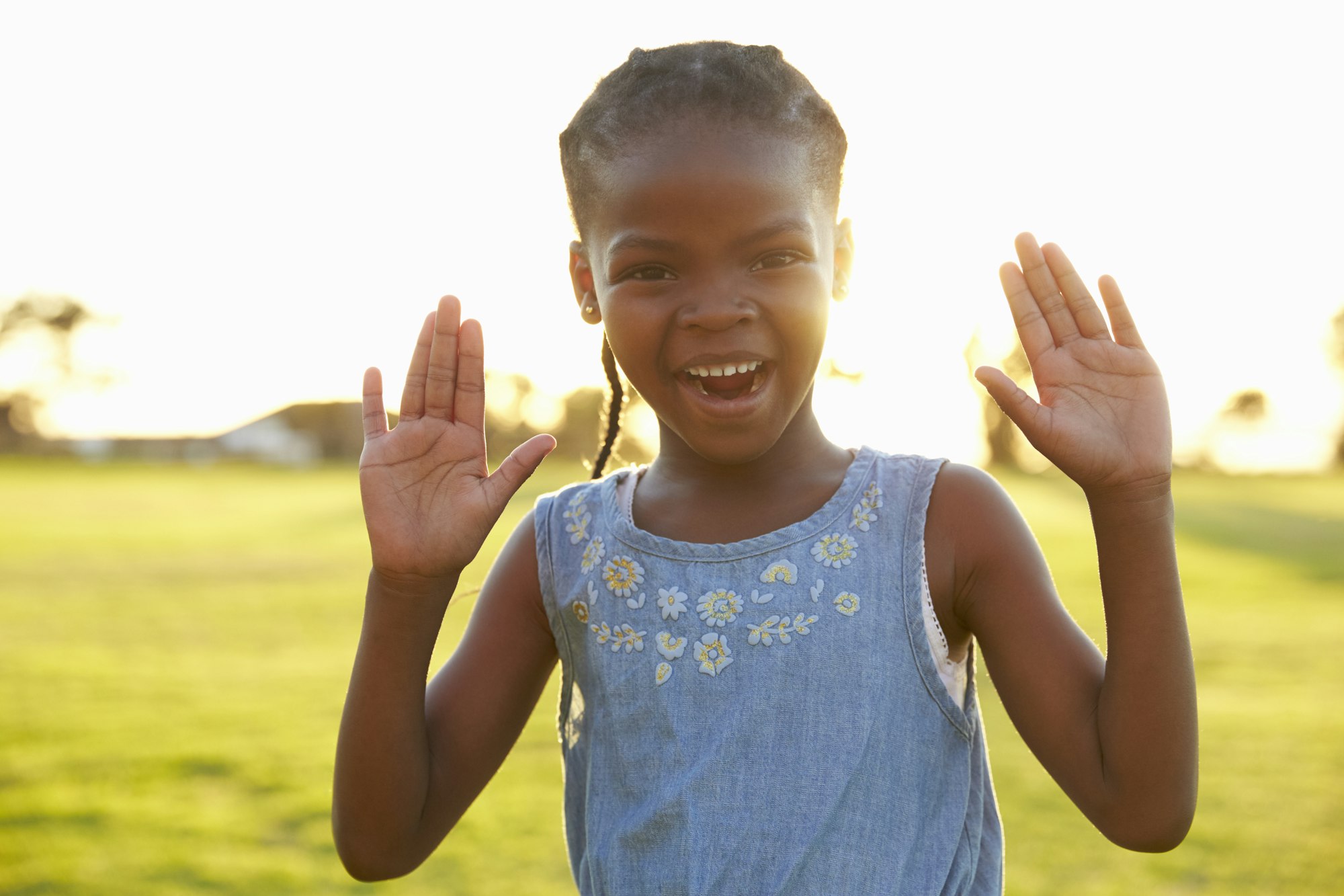 Portrait of African elementary school girl with hands raised as a kinesthetic memorization technique